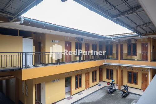 a building with two motorcycles parked in a parking lot at Wisma Handayani Syariah RedPartner near RSUD Wonosari in Yogyakarta