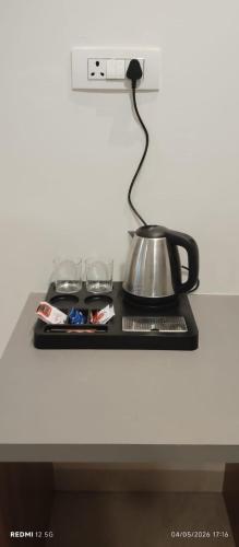 a counter with a tea kettle and glasses on it at hotel ananth inn in Mahālingpur