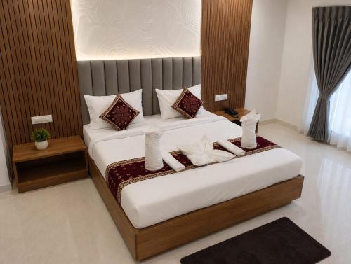 a bedroom with a large bed with white sheets and pillows at hotel ananth inn in Mahālingpur