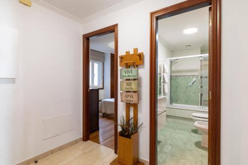 a bathroom with a toilet and a cross on the wall at Apartamento Río do Con Vilagarcía in Vilagarcia de Arousa