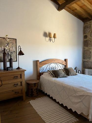 a bedroom with a bed and a dresser and lamp at Dão country house in Silgueiros