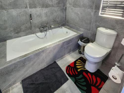 a bathroom with a toilet and a bath tub at Nonaka in Louis Trichardt