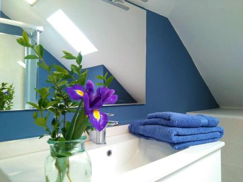 a bathroom with a vase with purple flowers on a sink at Playa Catedrales Village in Barreiros