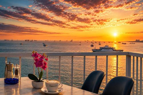 a table with a vase of flowers on a balcony with a sunset at Ayasofya Hotel - Special Class in Istanbul
