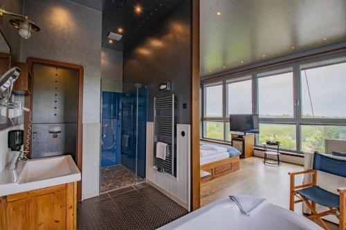 a bathroom with a tub and a bedroom with a bed at Hotel Dömitzer Hafen in Dömitz