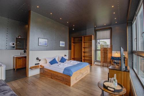 a bedroom with a large bed and a living room at Hotel Dömitzer Hafen in Dömitz