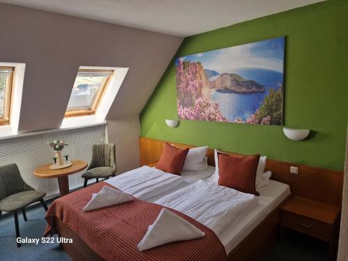 a bedroom with a bed and a painting on the wall at Hotel Restaurant Yiamas in Breitenworbis