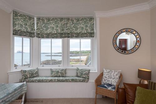 a window seat in a room with a view of the ocean at Bass Rock View in North Berwick