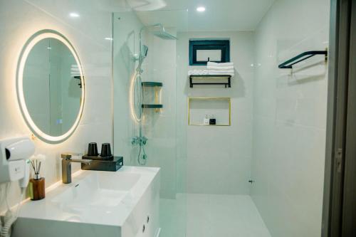 a white bathroom with a shower and a sink at Halo Motel Đồ Sơn in Ðố Sơn