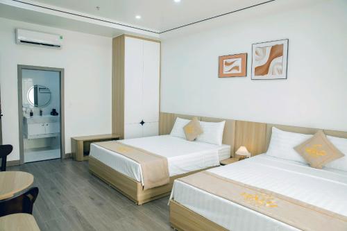 a hotel room with two beds and a table at Halo Motel Đồ Sơn in Ðố Sơn