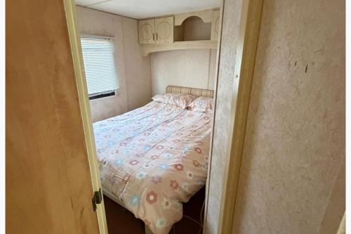 a small bedroom with a bed in a small room at Static Caravan Sleeps 8 with Indoor Pool in Clacton-on-Sea