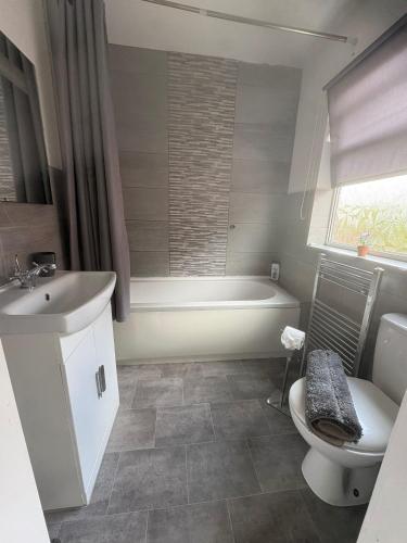 a bathroom with a tub and a toilet and a sink at Cosy 3 Bed house with garden 5 min walk from Doncaster Racecourse in Doncaster