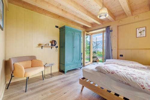 a bedroom with a bed and a chair and a window at Tenuta I Maroneri in Drena