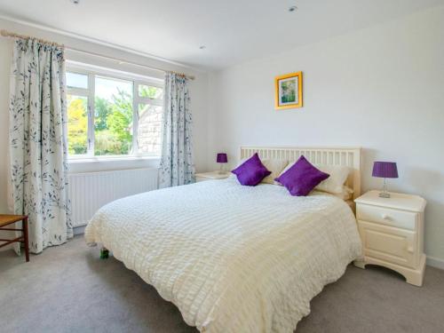 a bedroom with a large bed with purple pillows at 2 Bed in Wareham oc-75483 in Corfe Castle