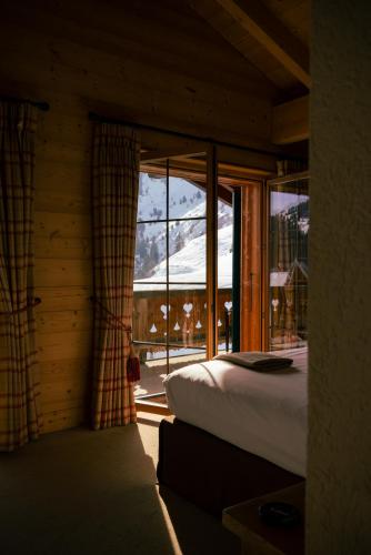 a bedroom with a bed and a large window at Mountain Lodge & Spa, Les Crosets in Les Crosets