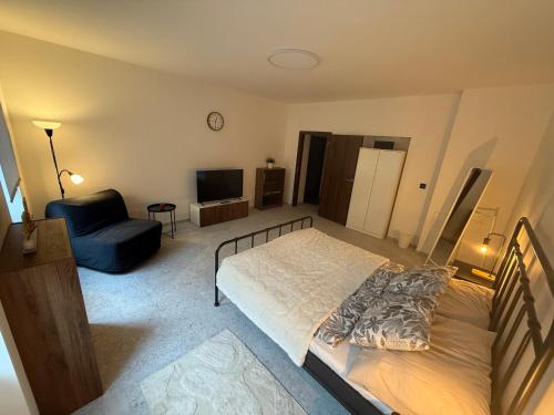 a bedroom with a bed and a chair at Hajkova Apartment in Jáma František