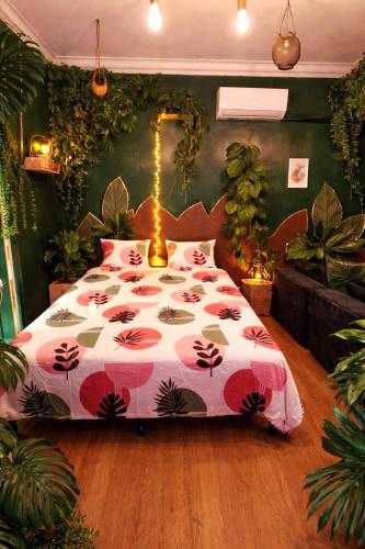 a bedroom with a bed with a floral bedspread at Le Studio Jungle climatisé in Graulhet