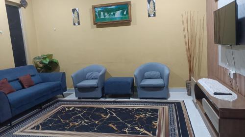 a waiting room with blue chairs and a tv at D'Shazly Homestay Village in Arau