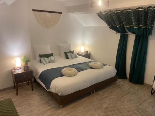 a bedroom with a large bed with green curtains at Le gîte des Romains in Anor