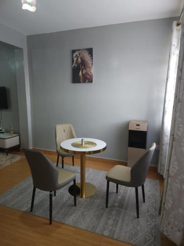 a room with a table and chairs and a picture of a horse at Zariah Homes 1 in Kakamega
