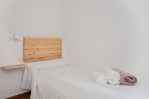 a bedroom with a bed with white sheets and towels at Villas 84 Est & Oest, Son Bou By MENORCARENTALS in Son Bou