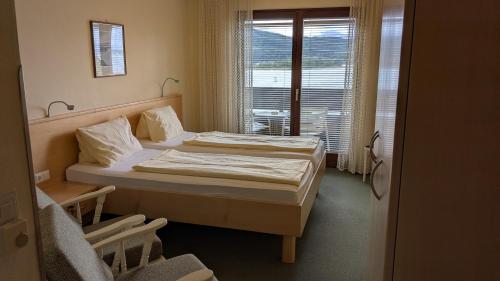 a small room with two beds and a window at Hotel Garni Vindobona in Pörtschach am Wörthersee