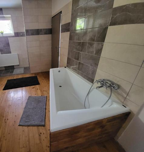 a white bath tub in a bathroom with a wooden floor at Apartmán u kolejí C in Klobouky u Brna