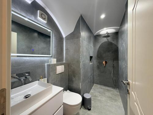 a bathroom with a sink and a toilet and a shower at Villa Aleandro in Ksamil