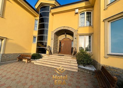 a hotel building with a wooden door and stairs at Hotel ERA in Prishtinë