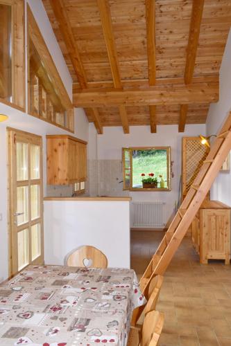 a kitchen and dining room with a table and a staircase at Chalet Brenta Dolomites in Madonna di Campiglio