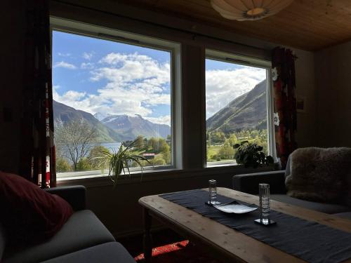 a living room with a table and a large window at Spacious House with Fjordview in Lauvstad