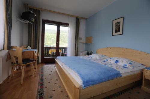 a bedroom with a bed and a table and a window at Gästehaus Luise in Ossiach