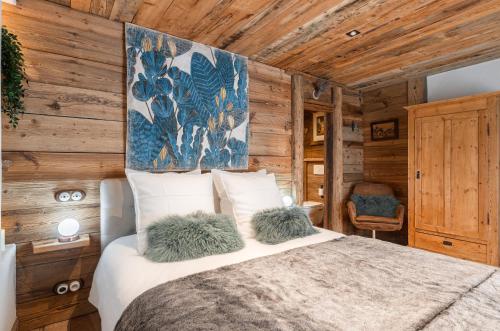 a bedroom with a bed in a room with wooden walls at La Ferme 1828 in Demi-Quartier