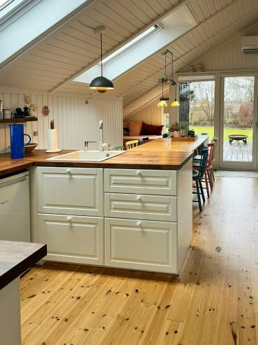 an open kitchen with white cabinets and a large island at Summer House With Authentic Charm On Enø in Karrebæksminde