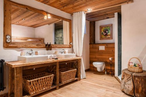 a bathroom with two sinks and a toilet at La Ferme 1828 in Demi-Quartier