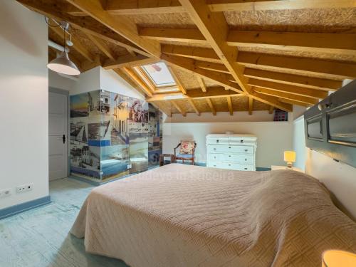 a bedroom with a large bed and wooden ceilings at Casas da villa - Apartments in Ericeira