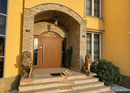 a front door of a building with two lion statues at Hotel ERA in Prishtinë