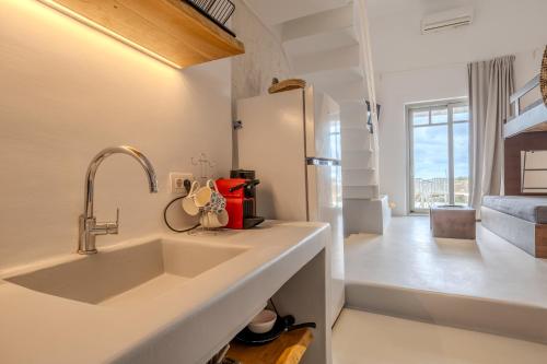 a kitchen with a sink and a refrigerator at Jo&Co Mykonos Nature Suites N3 in Plintri