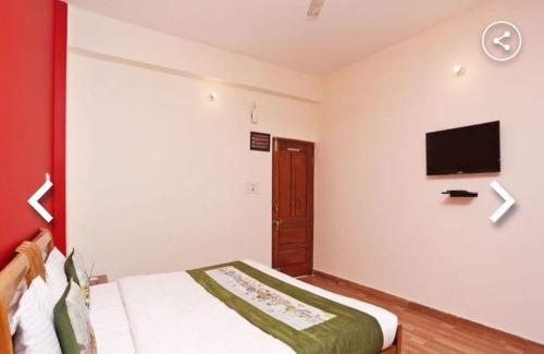 a bedroom with a bed and a flat screen tv at hotel gsa & guest house in Haridwār