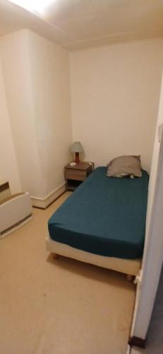 a small bedroom with a bed and a night stand at Studio privatif in Figeac