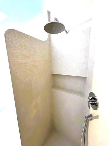a bathroom with a shower with a light on the wall at GG Luxury Apartments - Porto Cervo - Costa Smeralda in Porto Cervo