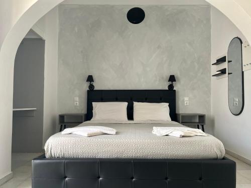 a bedroom with a large bed with a black headboard at Studios Zafiri in Naxos Chora