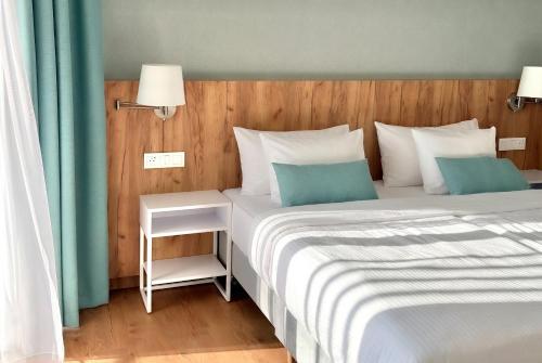 a bedroom with two beds with blue and white pillows at PINEA Resort in Pobierowo