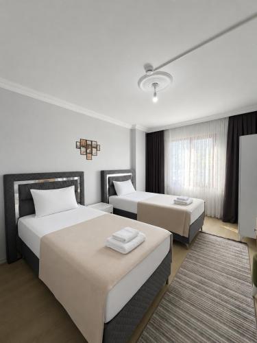 a hotel room with two beds and a tv at Rize Akarsu Apart in Rize