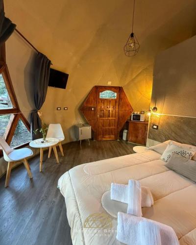 a bedroom with a large bed and a table and chairs at Aires de Berna in Villa Berna