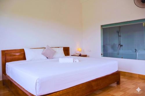 a bedroom with a large white bed with a shower at Tam Coc Sylvani Homestay in Vũ Lâm