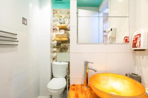 a bathroom with a wooden sink and a toilet at Limni Stone Apartments in Límni