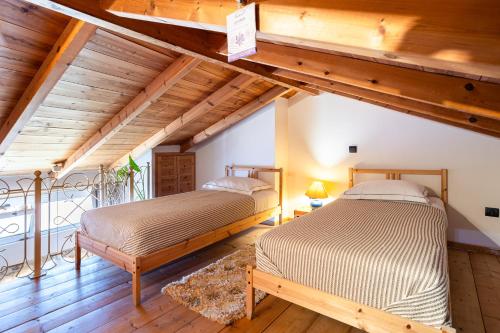 two beds in a room with wooden ceilings at Limni Stone Apartments in Límni