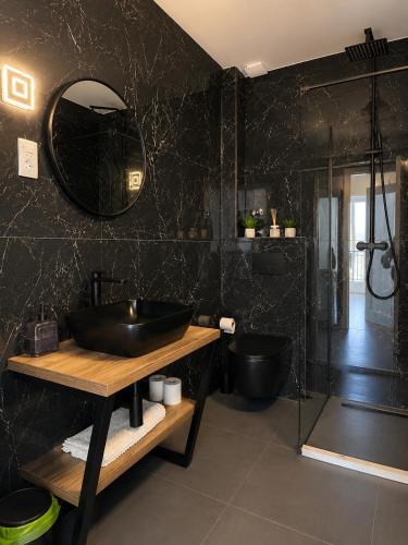 a black bathroom with a sink and a shower at AAA Luxury Suites Split with Pool in Split
