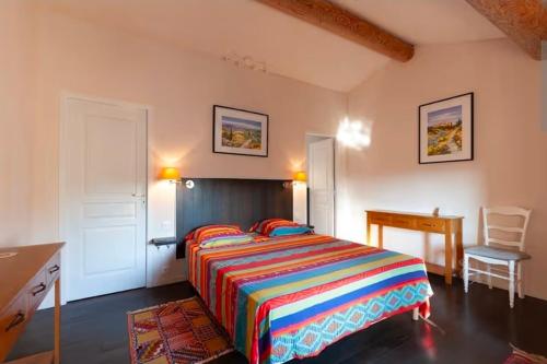 a bedroom with a bed and a desk and a chair at Gite DURANCE in Mallemort